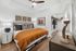 Bedroom with a king-sized bed, recessed ceiling with a fan, and a walk-in closet.