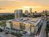 Mid-rise Hanover Parkview building, with retail on the first floor, trees lining the sidewalks, covered rooftop deck, and downtown Houston views