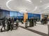 24-hour fitness center with weight machines, treadmills, ellipticals, stationary bikes, a squat rack, a punching bag, medicine balls, and two full walls of windows overlooking the city.