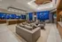 Clubhouse decorated with modern, neutral finishes, a marble dining table with 12 chairs, a seating area with three armchairs and a long couch, and beige carpet.