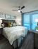 Bedroom with wood-style floors, en-suite bathroom, white walls, and a king-sized bed