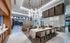 Lounge with floor-to-ceiling windows, a large sectional couch in front of an HDTV, a 10-person dining table, and a catering kitchen with bar-style seating