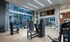 Gym with cardio equipment, weight machines, dumbbells, kettlebells, benches, multiple HDTVs, and wood-style floors