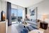 Living room with floor-to-ceiling windows with city views, large seating area and modern-wide plank wood-style flooring
