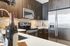 Open-concept gourmet kitchens with solid slab granite and quartzite countertops, stainless steel appliances and full-height backsplashes