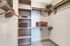 Walk-in closet with built-in shelves and closet rods across three walls