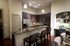 Kitchen with dark wood cabinets, stainless appliances, a granite-topped island, and a built-in desk with shelves.