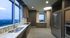 Large catering kitchen with fridge, freezer, double sinks, stove, dishwasher, and oven. The appliances are stainless steel and there is a window facing the skyline.