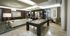Lounge space with a pool table, seating area with a white leather couch, and catering kitchen
