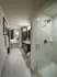 En-suite bathroom with a frameless glass walk-in shower, marble tile on the floor and shower walls, and dark wood cabinetry