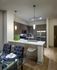 A kitchen with dark wood-style cabinets, stainless steel appliances, and a white quartz peninsula with 3 bar stools.