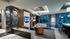 Seating area with a bar, 60-inch HDTV, large windows and modern, abstract sculptures.