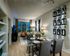 A living and dining room with light wood-style flooring, built-in shelves and contemporary furnishings.