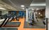 Gym with a wall of mirrors, treadmills, stationary bikes, ellipticals, weights and machines.
