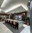 Resident pantry with a 5-seat breakfast bar, banquet seating, stainless steel appliances, and a flat-screen TV.