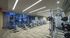 Gym with weight machines, treadmills, stationary bikes, floor-to-ceiling windows, and carpeted floors.