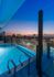 The end of the pool extends out on a ledge with a glass wall, so that the pool appears to drop off the edge of the building. Looking northeast, the viewer can see the Uptown Galleria skyline.