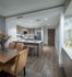 Open-concept kitchen with dark wood-style floors, a large peninsula, stainless steel appliances, and ash-blond wood cabinets.