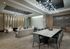Lounge decorated with modern, neutral finishes, a marble dining table with 12 chairs, a seating area with three armchairs and a long couch, and beige carpet.