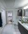 Spacious bathroom with marble floors, a bathtub with a shower curtain, dark wood cabinets, granite countertops, and a carpeted walk-in closet.