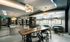 Resident catering kitchen with barstools at a large marble island, cafe-style seating along the wall, and a 6-person wood dining table.