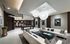 Clubhouse with dark wood-paneled walls, a pool table, two long white couches around a coffee table, and a resident catering kitchen with a wet bar.