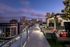 A landscaped rooftop entertaining area with a city skyline view and multiple dining and seating areas.
