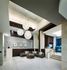 Spacious lobby with high ceilings, a modern globular chandelier, marble floors, a concierge desk, and a curved couch around a coffee table.