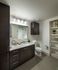 Bathroom with dark wood cabinets, a granite countertop, and open built-in shelves.