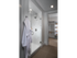 Bathroom with a glass-door walk-in shower, light brown tile floors, and an entrance to a walk-in closet.