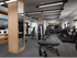 Indoor gym with wood-framed mirrors, treadmills, benches, an elliptical, weights and machines.