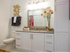 A bathroom vanity with a quartz countertop, white cabinets and drawers below the sink, and cabinets up to the ceiling beside the vanity.