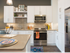 A kitchen with white cabinets, under-cabinet task lighting. and stainless steel appliances.