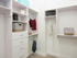 A large walk-in closet with modular storage, including full-length and half-length spaces with closet rods, four dresser drawers, and shelves.