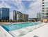 Outdoor pool deck with a lounge chairs and a skyline view.