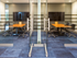 Two glass-walled conference rooms, each with a large HDTV on the wall and four rolling leather chairs around a conference table.