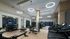 Gym with cardio equipment, weight machines, dumbbells, kettlebells, benches, multiple HDTVs, and wood-style floors