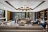 Resident Lounge with floor-to-ceiling windows, upholstered armchairs and sofas with coffee tables centered around a gas indoor fireplace.