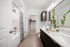 bathroom with two sinks, large mirror, shower tub combo and closet attached