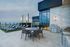 rooftop lounge area with grills dining table and sun loungers