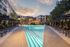 large resort style pool surrounded with sun loungers and umbrellas