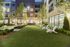 green lawn space with adirondack chairs and landscaping surrounding