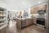 apartment kitchen with brown wood flooring, white counters, brown cabinets and stainless steel appliances