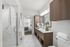 bathroom with white marble tile, white counters, and glass framed shower
