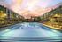 resort style pool at sunset with sun loungers and umbrellas on either side
