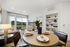 living and dining area with built in bookshelves and floor to ceiling windows