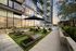 angled view of the cushioned chaise loungers next toa resort style pool of a highrise building