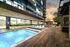 narrow resort style pool deck of high-rise with wood tile flooring and cabanas and sun loungers