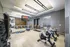 fitness studio with free weights, 3 spin bikes facing a mirrored wall with TV and ballet bar