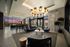 large club room with l-shaped sofa and bar height dining table under a large circular light fixture
